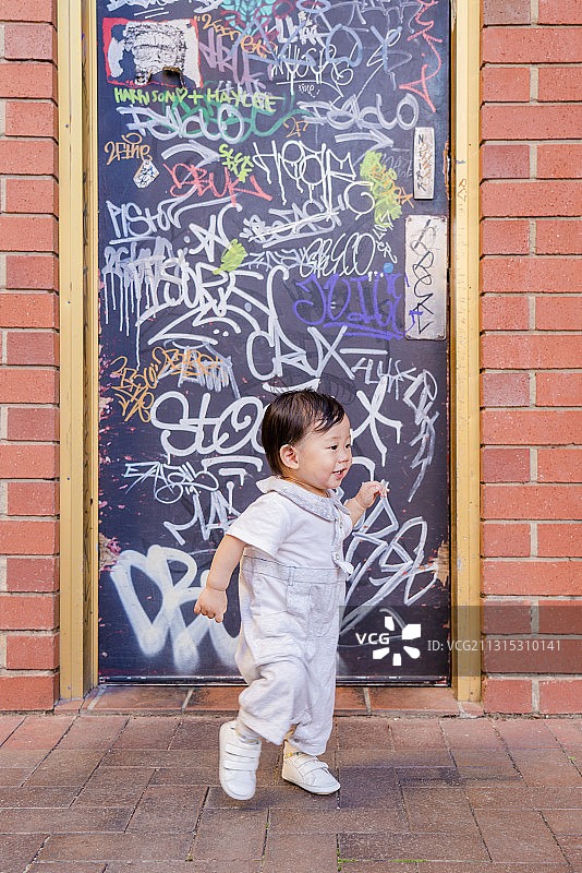 红砖艺术墙前的男婴图片素材