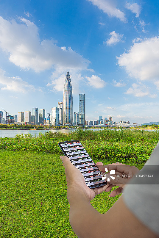 深圳后海金融区人才公园天际线和拿着手机看股票的金融市场概念图片素材