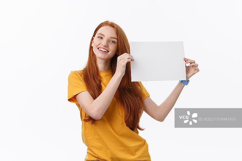 微笑的年轻女子举着空白的布告在白色的背景图片素材