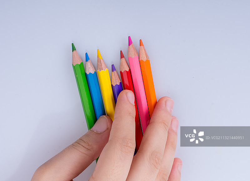 裁剪的手的孩子与彩色铅笔在白色的背景图片素材