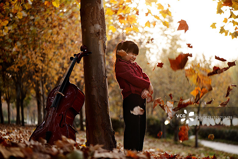 在树林里拉大提琴的小女孩图片素材