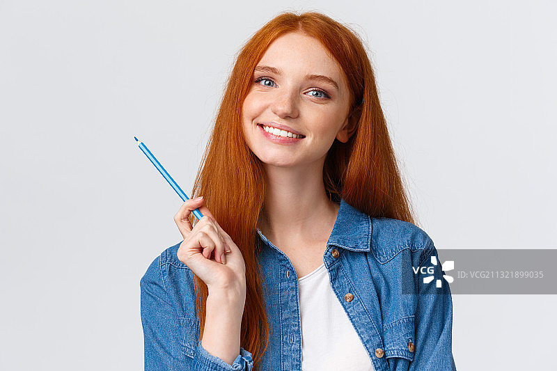 微笑的年轻女子的肖像拿着铅笔对白色的背景图片素材