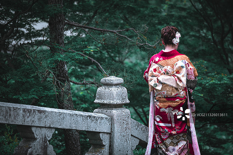 日本京都清水寺石桥上穿传统和服头上戴鲜花的日本女孩背影图片素材