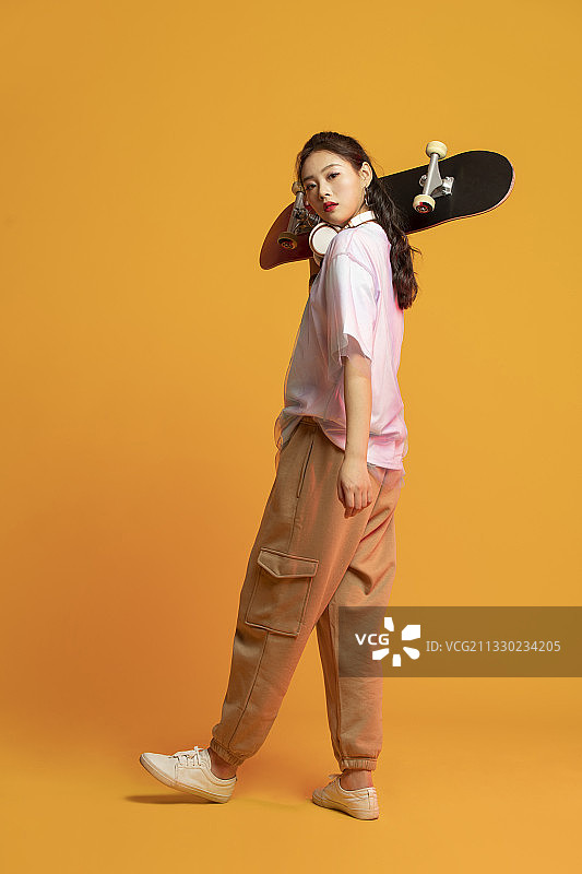 时尚的年轻女孩拿着滑板图片素材