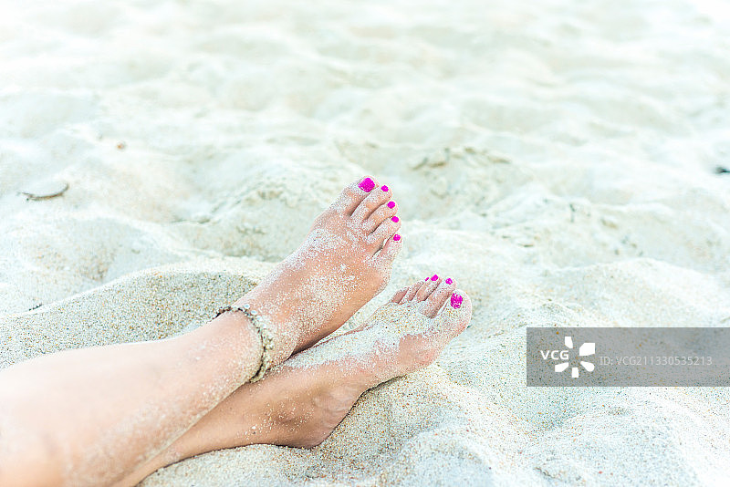 沙滩上的女人脚上有粉红色的脚趾甲图片素材