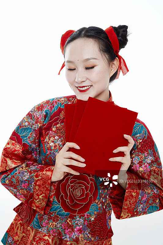 白色背景下穿着秀禾服手拿红包的亚洲少女图片素材