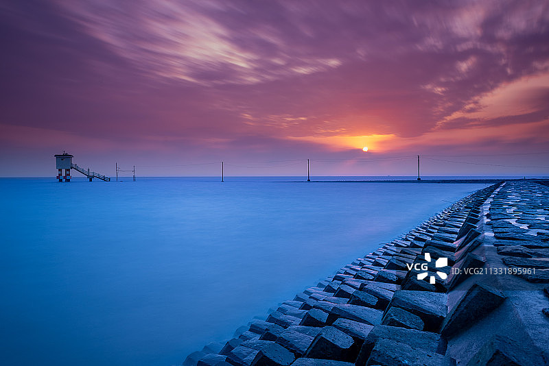 日出时分长江口的横沙岛水文站小屋孤零零地立在汹涌的大海里图片素材