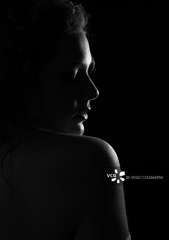 赤裸上身的年轻女子对黑色背景的特写，希腊图片素材