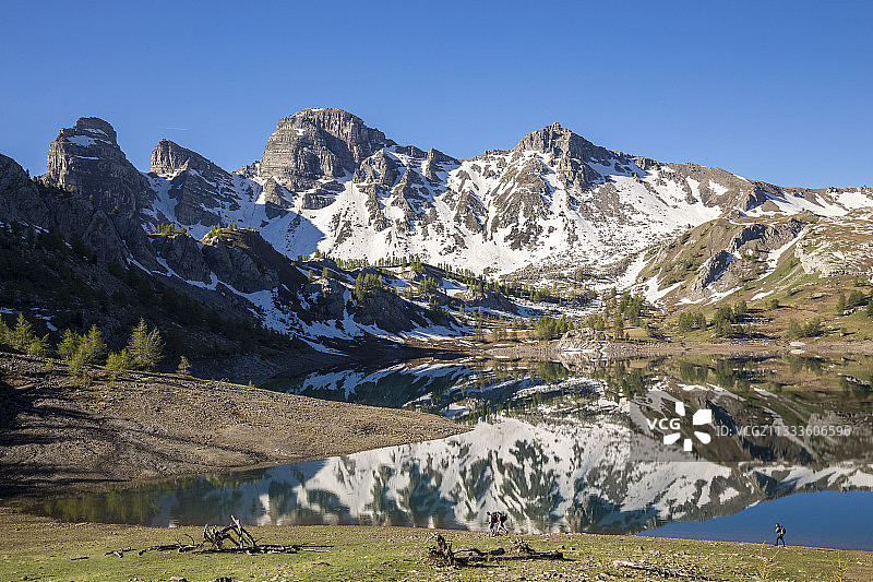 徒步者在阿洛斯湖(2226米)的岸边，背景是上verdon的tour du Lac, Mercantour国家公园，阿尔卑斯山，法国图片素材