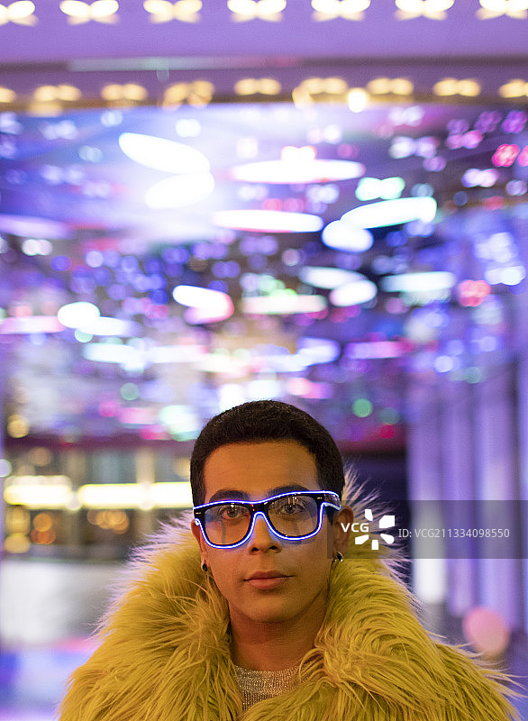 肖像时尚的年轻人在羽毛围巾和霓虹灯眼镜图片素材