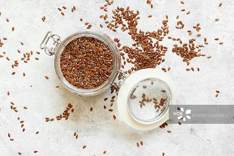 生亚麻籽在一个罐子和勺子图片素材