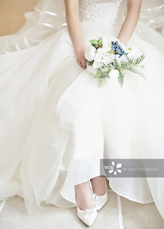 低段女子穿着婚纱坐着捧着花束图片素材
