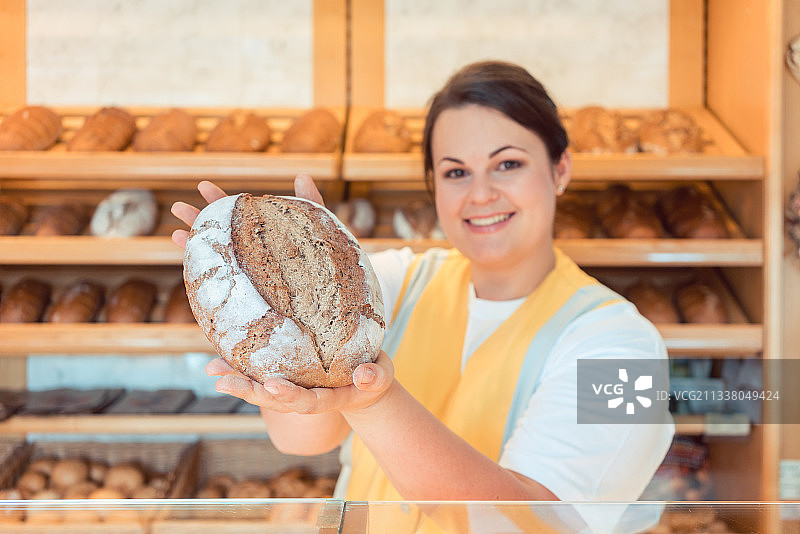 面包店女售货员向潜在买家介绍面包图片素材