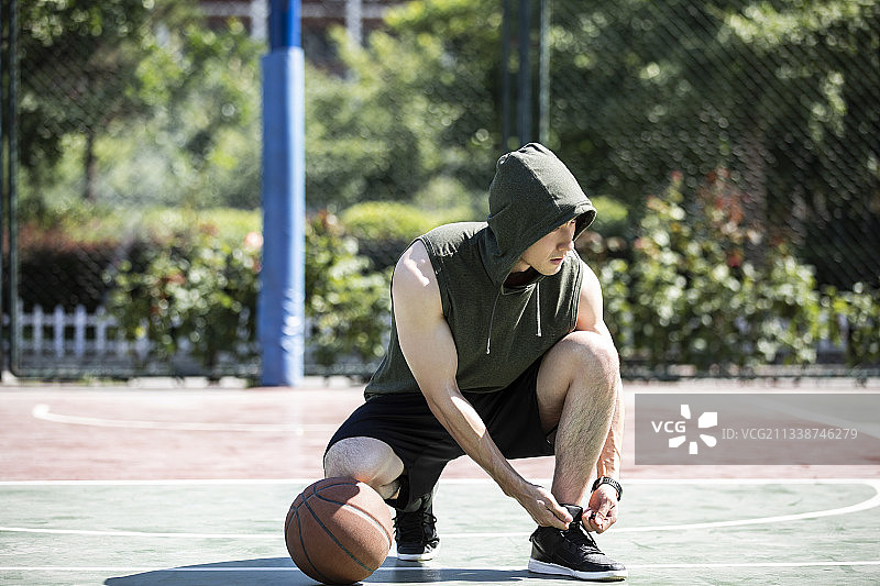 一个青年男子准备打篮球系鞋带肖像图片素材