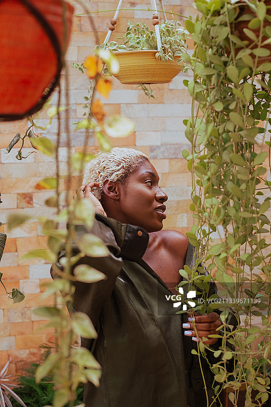 在加纳的阿克拉，站在植物旁的妇女看向别处图片素材