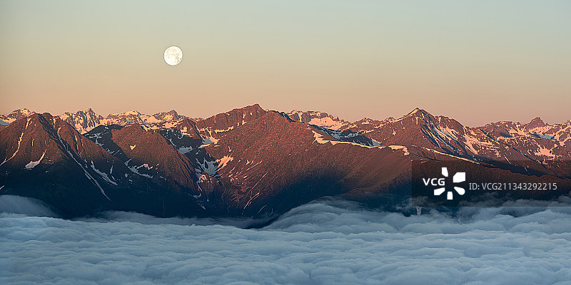 日落时分，白雪皑皑的山峦映衬着天空图片素材