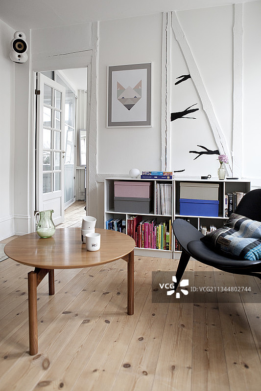咖啡桌，黑色的设计师椅子和半高的架子在客厅图片素材