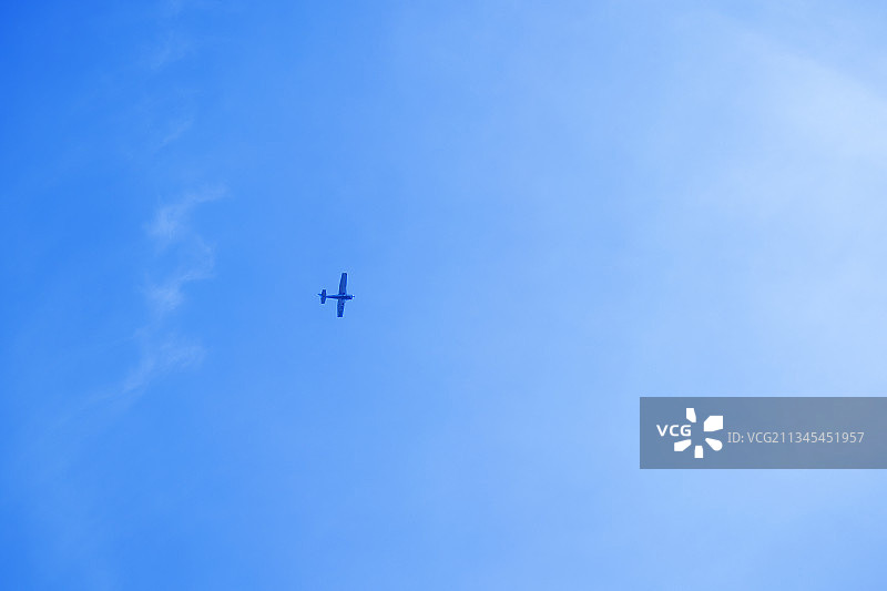 飞机在蓝天下飞行的低角度视图图片素材