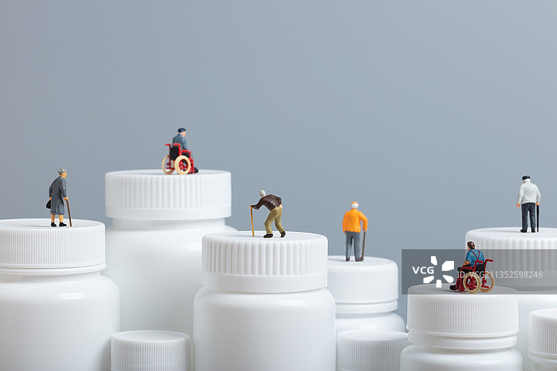 微缩创意大量白色药瓶上的老年人医疗健康图片素材
