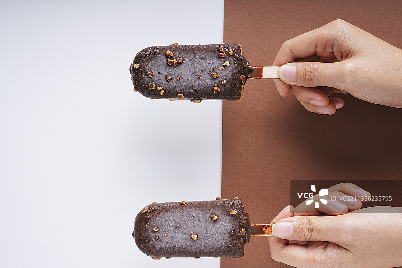 俯视图-巧克力榛子冰淇淋粘在白色和棕色背景。两个。图片素材