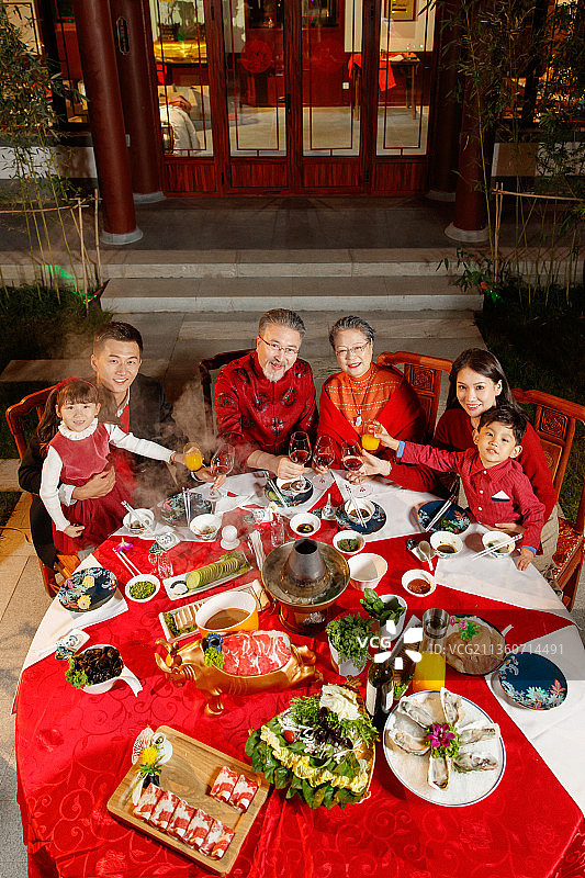 东方家庭在中式庭院内干杯庆祝新年图片素材