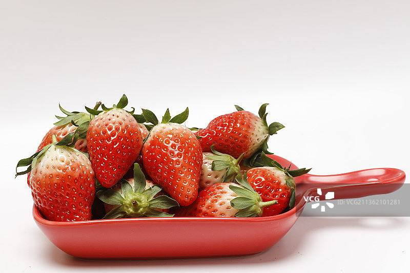 白色背景，红色盘子里的草莓图片素材