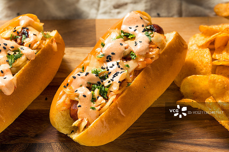 自制的韩国泡菜热狗，桌子上的汉堡和炸薯条的特写图片素材