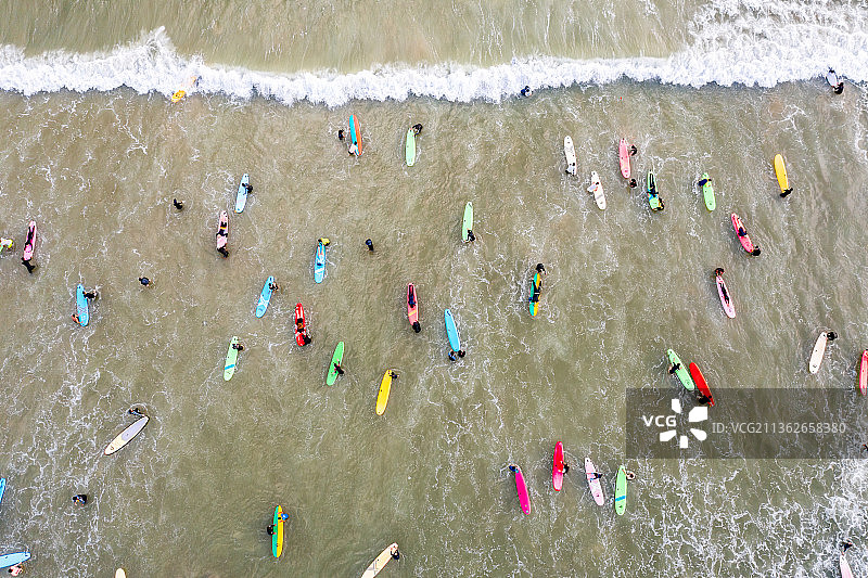 海南省三亚市海棠区后海度假村游客正在海边冲浪图片素材