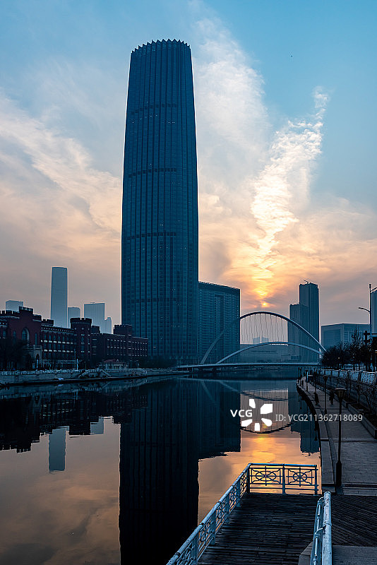 傍晚拍摄中国天津海河边的高楼大厦的剪影和日落倒影图片素材