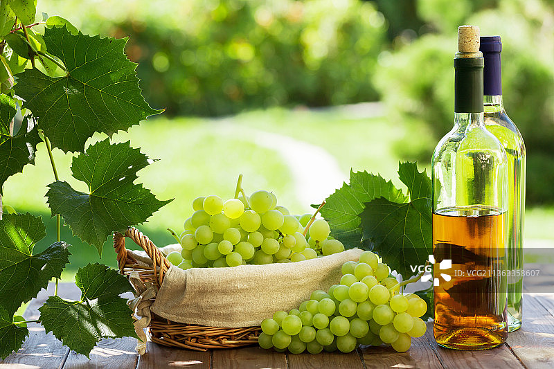 白葡萄酒和葡萄，酒瓶和葡萄的特写图片素材