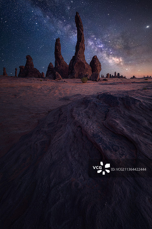群山环抱着繁星，夜晚的天空衬托着岩石形成的风景图片素材