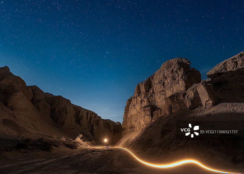 蓝色星空下地下峡谷的神秘光轨图片素材