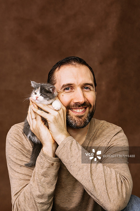 男人和小猫玩耍拥抱他，亲吻他图片素材