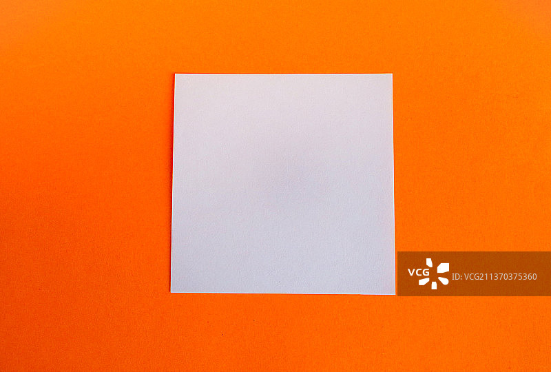 在明亮的橙色背景上，一个空白的白色方形构图图片素材