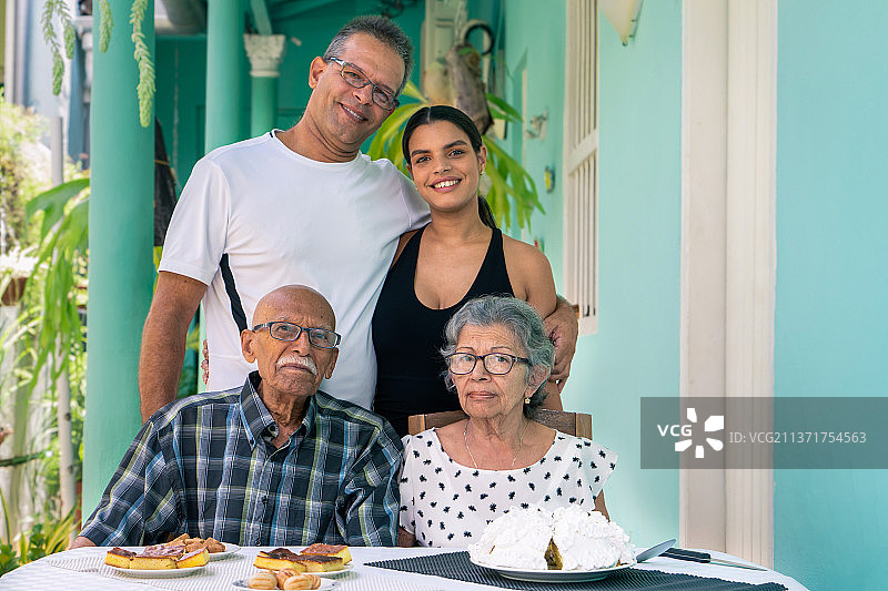 家庭照片，祖父母，儿子和孙女，家人坐在桌子旁的肖像，圣克拉拉，古巴图片素材