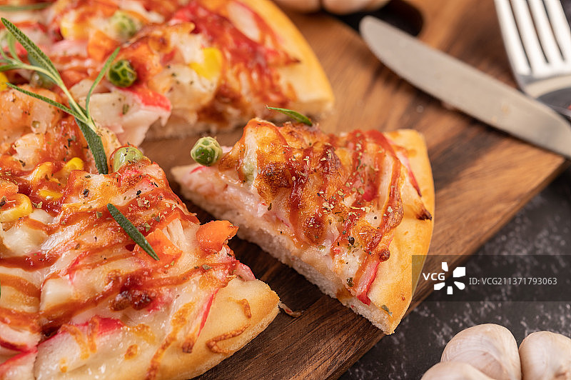 披萨放在木盘上，披萨特写放在切菜板上图片素材
