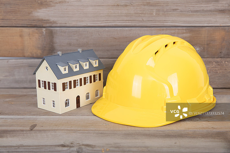 建筑业黄色安全帽和小房子模型图片素材