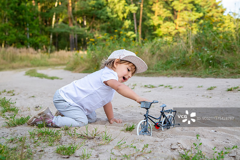 可爱的幼儿玩玩具自行车在大自然的孩子在所有的四图片素材