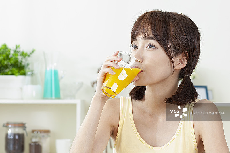 正在喝着柳橙汁的东方美女图片素材