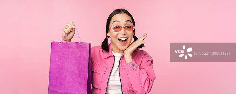 购物时尚的亚洲女孩太阳镜，展示包从商店和图片素材