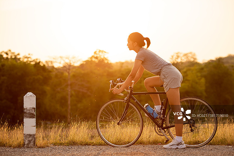 泰国，日落时分骑自行车的女人图片素材