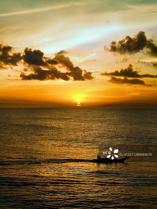 遇见早晨的地平线，日落时海上的船在天空的剪影，巴图卡拉斯，印度尼西亚图片素材