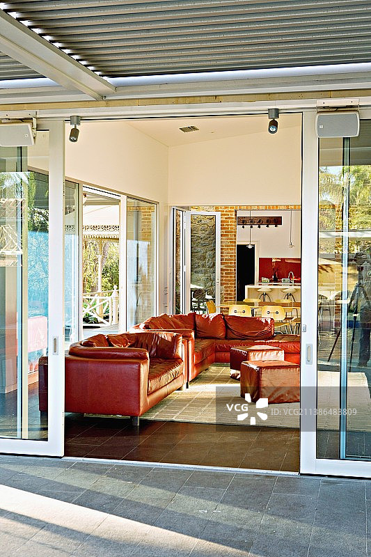 通过客厅里红色真皮沙发的滑动门可以从露台上看到图片素材