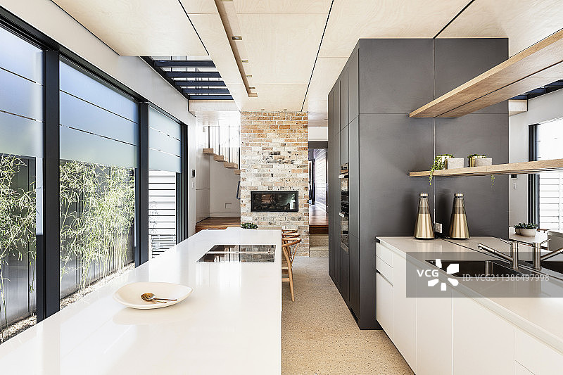 现代厨房在狭窄的建筑师设计的房子与玻璃墙图片素材