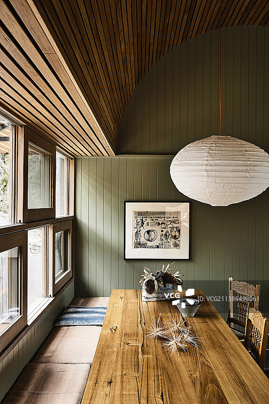 厨房窗户下的餐桌和长凳，采用绿色木镶板图片素材