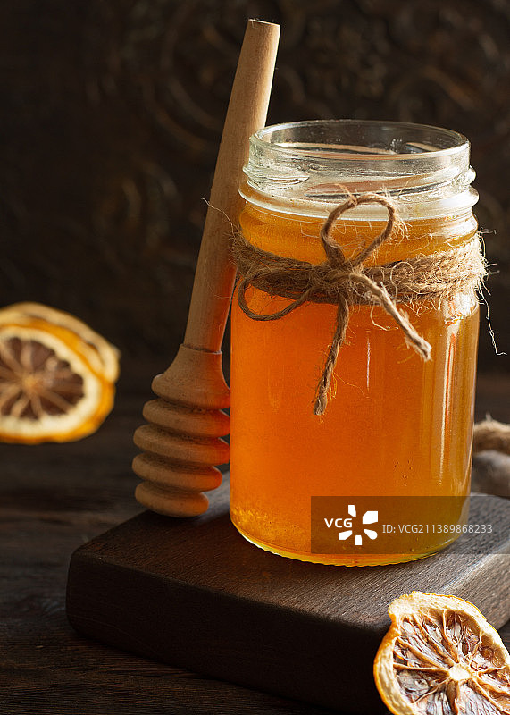 椴树蜂蜜与干柠檬和蜂蜜匙组成图片素材