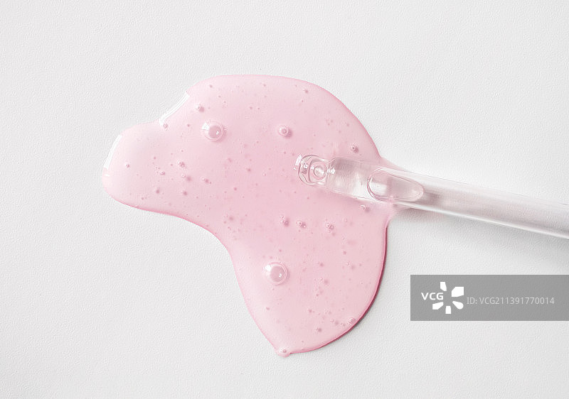 带粉红色透明质酸液的移液器，单色灰色背景图片素材