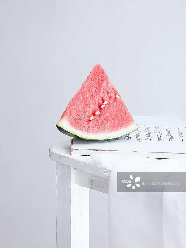 白色桌面上摆放着的新鲜夏日水果西瓜图片素材