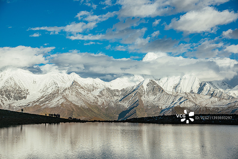 雄伟雪山在高山湖泊上的倒影图片素材