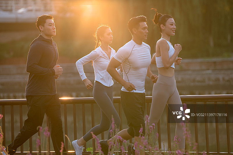 四个年轻人在城市公园里跑步图片素材